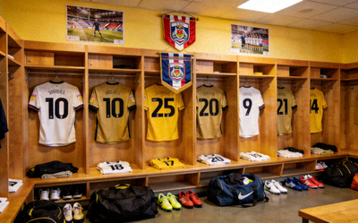 更衣室内景，球衣悬挂在衣柜中，充满团队氛围